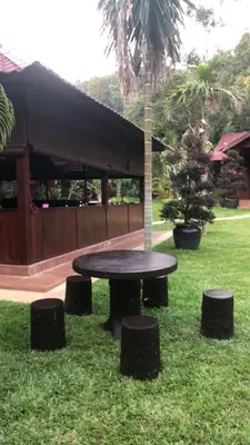 a picnic table in the grass next to a building at Kemuning Orchard Villaa in Kerling
