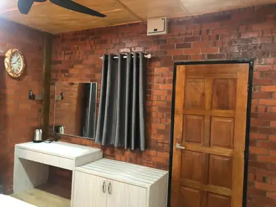 a bathroom with a sink and a brick wall at Kemuning Orchard Villaa in Kerling