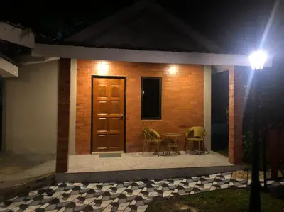 a small house at night with a table and chairs at Kemuning Orchard Villaa in Kerling