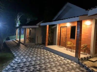 a small house with a patio at night at Kemuning Orchard Villaa in Kerling