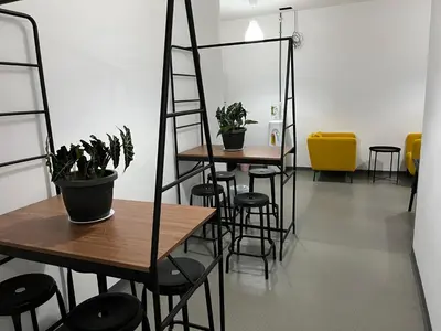 a room with two tables and chairs with plants at Knight Alley Hotel in Taiping