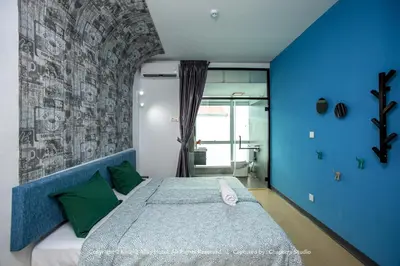 a bedroom with a large bed with a blue wall at Knight Alley Hotel in Taiping