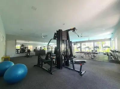 a room with a gym with a treadmill and weights at Manhattan Condo Ipoh with Water Park and Pool View in Ipoh