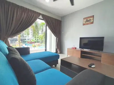 a living room with a blue couch and a tv at Manhattan Condo Ipoh with Water Park and Pool View in Ipoh