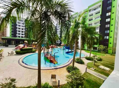 a pool with a slide in a courtyard with palm trees at Manhattan Condo Ipoh with Water Park and Pool View in Ipoh