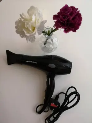 a black hair dryer next to a vase of flowers at W5WarmStay@Golden Hill/Penthouse/WiFi/3R/NightMarket/2CarPark in Brinchang