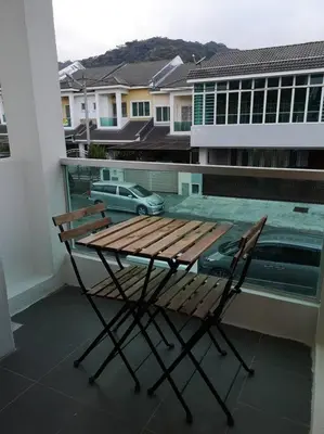 a wooden table and a chair on a balcony at W36 WarmStay atGoldenHills NightMarket 4R Wifi BBQ in Brinchang