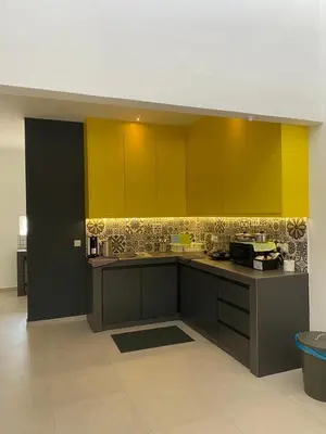 a kitchen with yellow and green cabinets in a room at Guesthouse @ Ipoh garden II in Ipoh