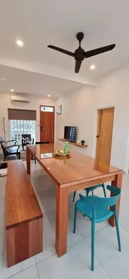a dining room with a wooden table and a blue chair at Guesthouse @ Ipoh garden II in Ipoh
