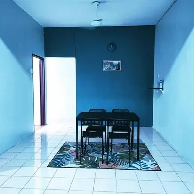 a table and two chairs in a room with a blue wall at Homestay De' Humaira - USM Nibong Tebal in Nibung Tebal
