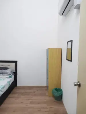 a bedroom with a bed and a wooden cabinet at Homestay De' Humaira - USM Nibong Tebal in Nibung Tebal