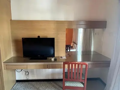 a desk with a television and a chair in a room at Paradise by the Sea in Penang by Veron at Rainbow Paradise in Tanjung Bungah
