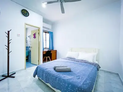 a bedroom with a bed with a blue comforter at Tupai Mas Semi-D 4BR 2mins to LakeGarden & Zoo in Taiping
