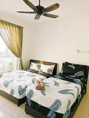 a bedroom with two beds and a ceiling fan at Mansion One Two Bedroom Seaview 7 Pax in George Town
