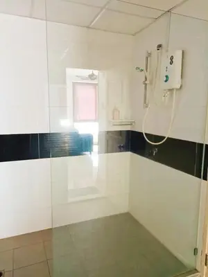 a bathroom with a shower with a glass door at Mansion One Two Bedroom Seaview 7 Pax in George Town