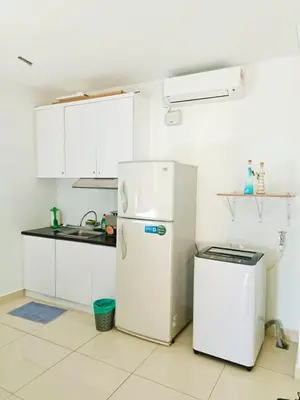 a kitchen with white cabinets and a white refrigerator at Mansion One Two Bedroom Seaview 7 Pax in George Town