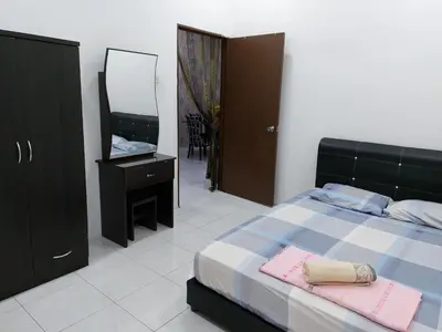 a bedroom with a bed and a dresser and a mirror at Pelangi homestay in Kampung Bota Kiri