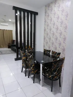 a dining room with a black table and chairs at Pelangi homestay in Kampung Bota Kiri
