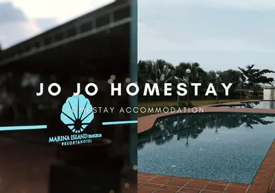 a sign for theku homogeneitystay association next to a body of water at Jo Jo Homestay @ Marina Island Laguna in Lumut
