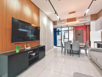 a living room with a large television on a wall at Beacon Executive Suite at Georgetown for 10pax and 2 BED ROOM in George Town