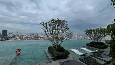 a person in a pool of water with a city in the background at Beacon Executive Suite at Georgetown for 10pax and 2 BED ROOM in George Town