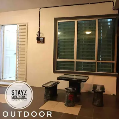 a table and two stools in a room with a window at Stayz Guesthouse in Sungkai