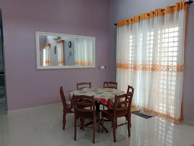 a dining room with a table and chairs and a mirror at Mysa Homestay in Kampong Batu Dua