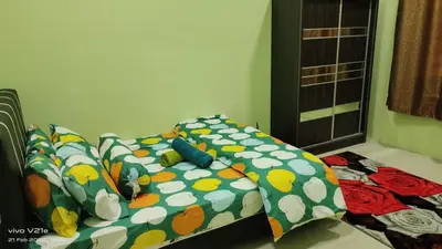 a bed with a comforter and pillows on it at Mysa Homestay in Kampong Batu Dua
