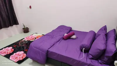 a purple couch with pillows on it in a room at Mysa Homestay in Kampong Batu Dua
