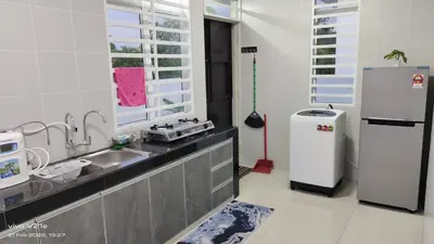 a kitchen with a sink and a refrigerator at Mysa Homestay in Kampong Batu Dua