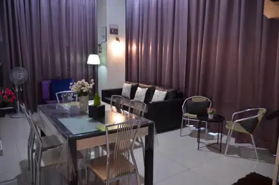 a living room with a table and chairs and a couch at MARITIME SUITE DUPLEX PENANG- PEMANDANGAN LAUT in George Town