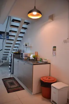 a kitchen with a counter and a sink and a staircase at MARITIME SUITE DUPLEX PENANG- PEMANDANGAN LAUT in George Town