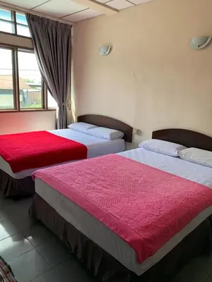 two beds in a hotel room with red sheets at HOTEL MIRAMA \u7f8e\u9e97\u83ef\u9152\u5e97 in Sitiawan
