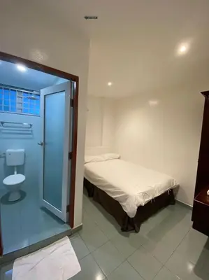 a small bedroom with a bed and a glass door at HOTEL MIRAMA \u7f8e\u9e97\u83ef\u9152\u5e97 in Sitiawan
