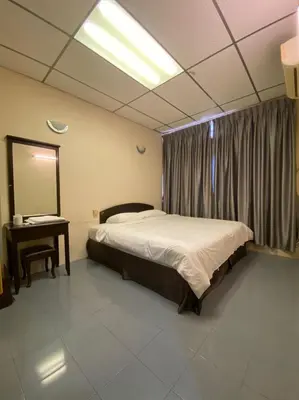 a bedroom with a bed and a mirror and a table at HOTEL MIRAMA \u7f8e\u9e97\u83ef\u9152\u5e97 in Sitiawan
