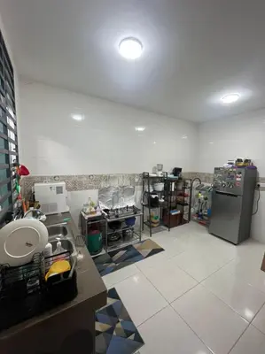 a kitchen with a counter and a refrigerator at Hadeerna Homestay - Double storey terrace in Chemor