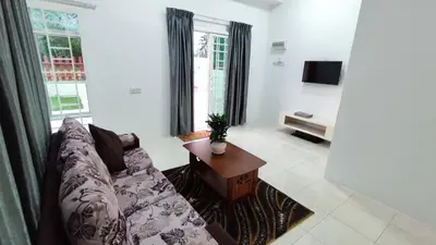 a living room with a couch and a table at Malim Nawar holiday house in Malim Nawar