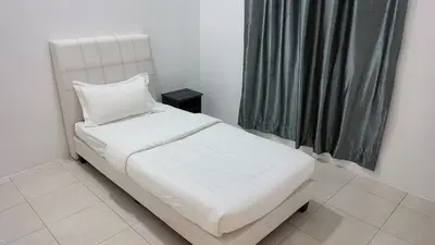 a small bedroom with a white bed and a window at Malim Nawar holiday house in Malim Nawar