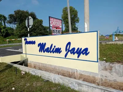 a sign for a mallini plaza on the side of a road at Malim Nawar holiday house in Malim Nawar