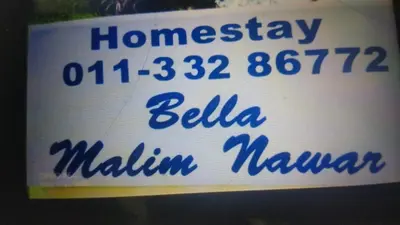 a white sign with blue writing on it at Malim Nawar holiday house in Malim Nawar