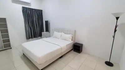 a white bed in a white room with a lamp at Malim Nawar holiday house in Malim Nawar