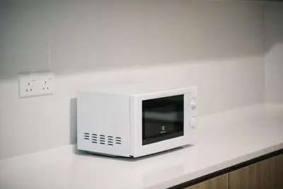 a white microwave sitting on top of a counter at The GRANDE @ Tropicana 218 Macalister in George Town