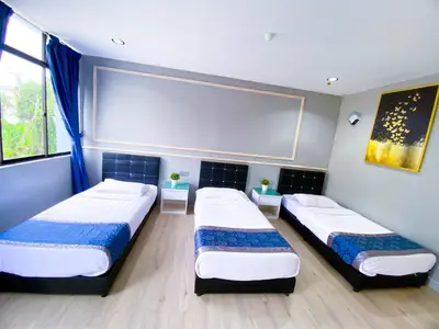 a room with three beds in a room at 61 Hotel in Gua Musang