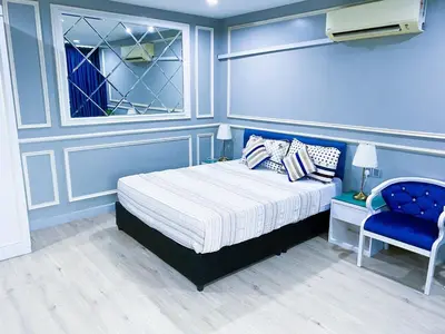a blue bedroom with a bed and a blue chair at 61 Hotel in Gua Musang
