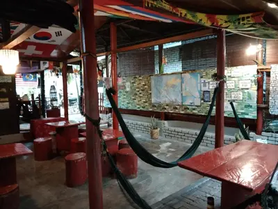 a restaurant with red tables and a hose at Nazri Nipah Camp Pangkor in Kampung Teluk Nipah