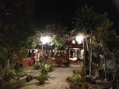 a garden at night with lights and palm trees at Nazri Nipah Camp Pangkor in Kampung Teluk Nipah