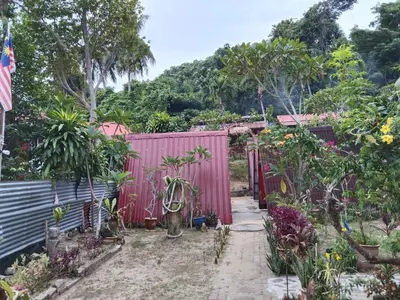 a garden with a red fence and plants at Nazri Nipah Camp Pangkor in Kampung Teluk Nipah