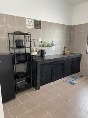a kitchen with a black counter with a sink and a counter at Anas House in Tanjung Rambutan