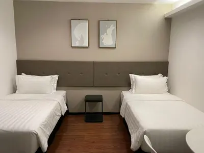 a room with two beds and two pictures on the wall at King's Lane Ipoh in Ipoh