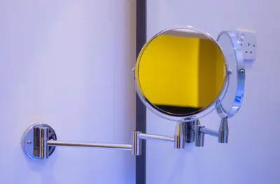 a round mirror on a door with a yellow at King's Lane Ipoh in Ipoh